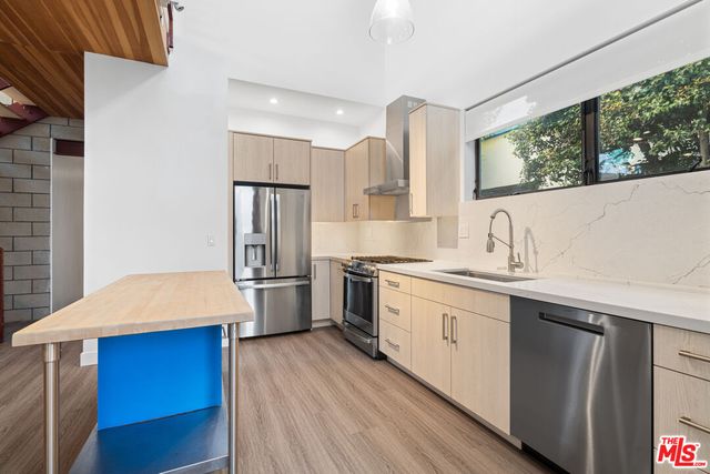 a kitchen with stainless steel appliances a sink cabinets and wooden floor