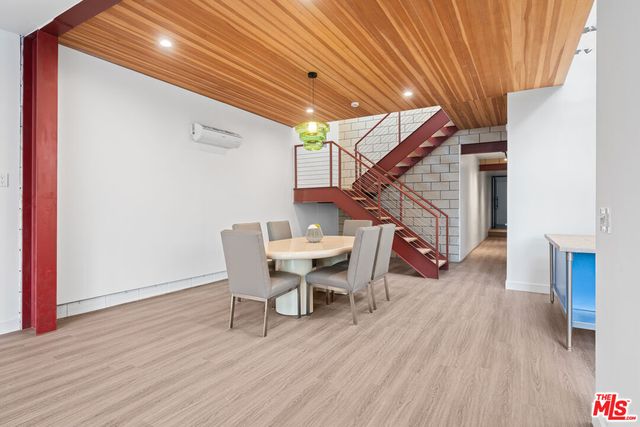 a dining room with wooden floor a table and chairs
