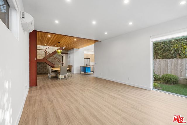 an empty room with wooden floor table and chairs