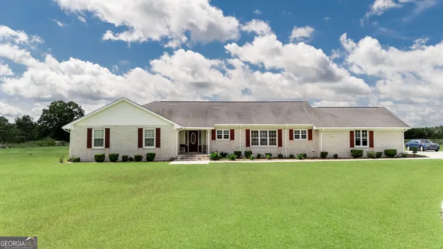 a big white house with a big yard and large trees