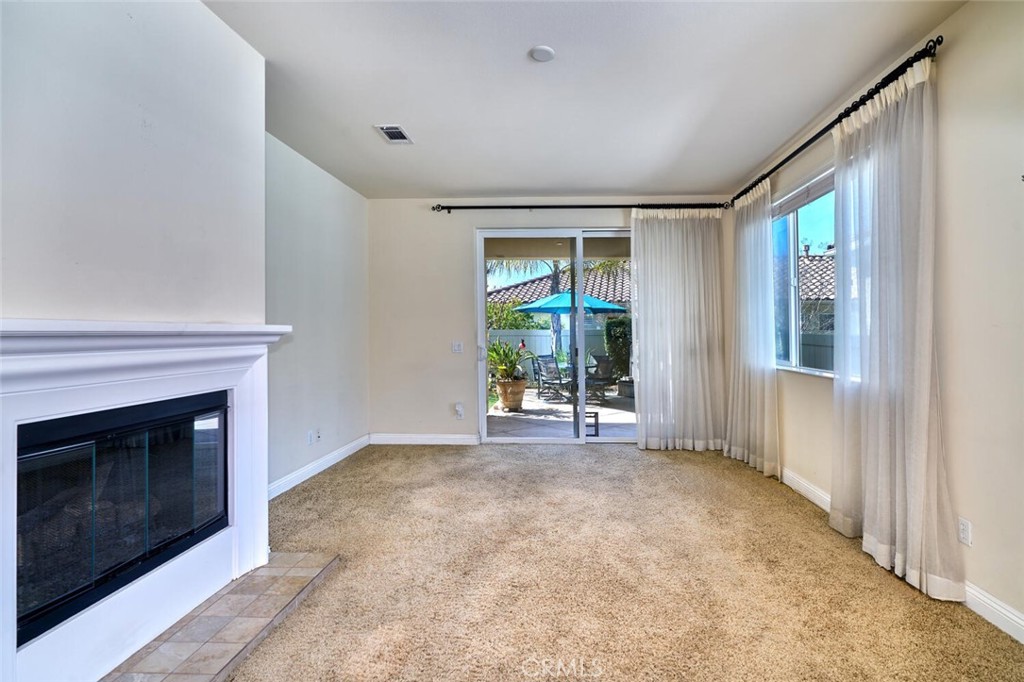 1143 Saguara Road Beaumont, CA 92223 - Photo 33 of 66 a view of an empty room with a fireplace and a window