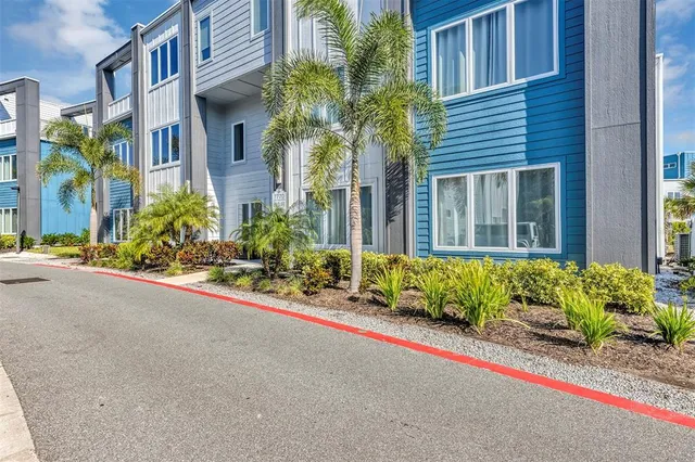 a view of a house with potted plants and a small yard
