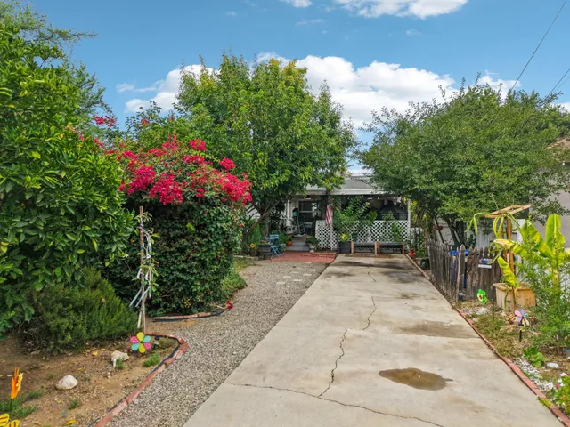 a kitchen with stainless steel appliances granite countertop a refrigerator a stove oven a sink dishwasher and white cabinets with wooden floor