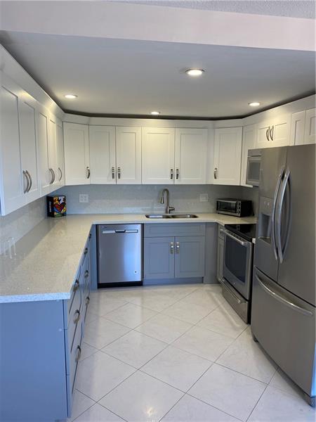a large kitchen with a large counter top appliances and cabinets