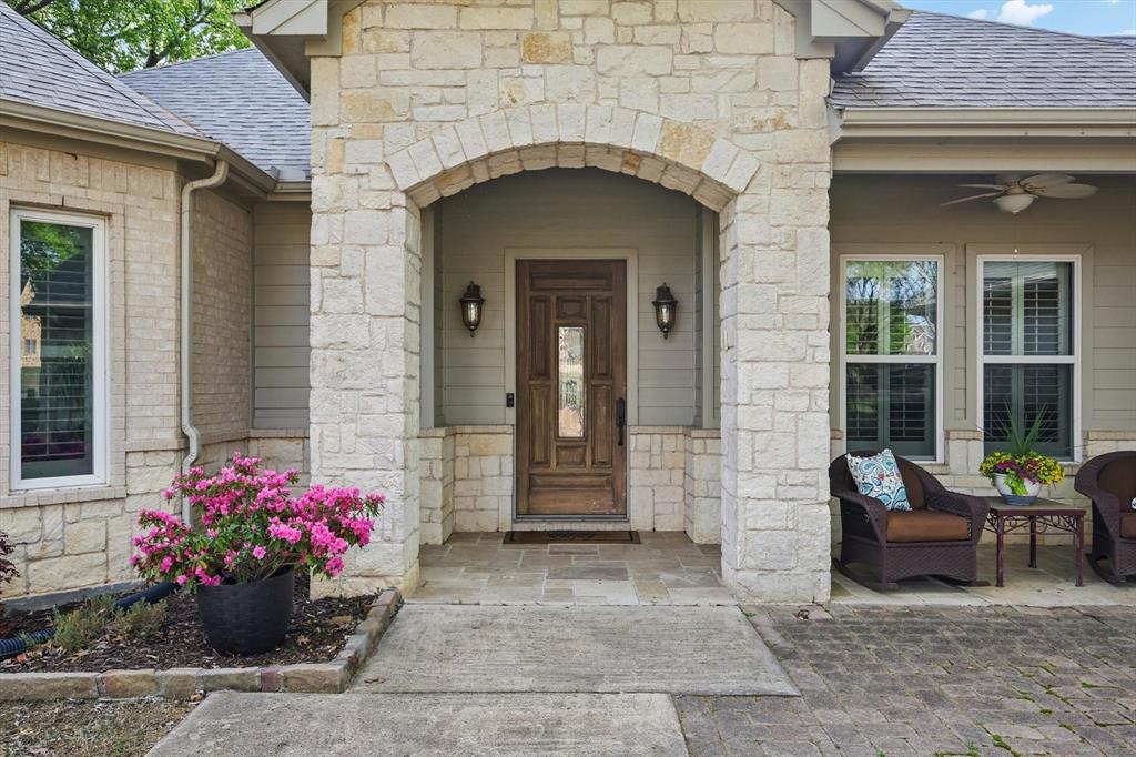 8517 Stallion Street Denton, TX 76208 - Photo 2 of 36 a front view of a house with a bench and flowers
