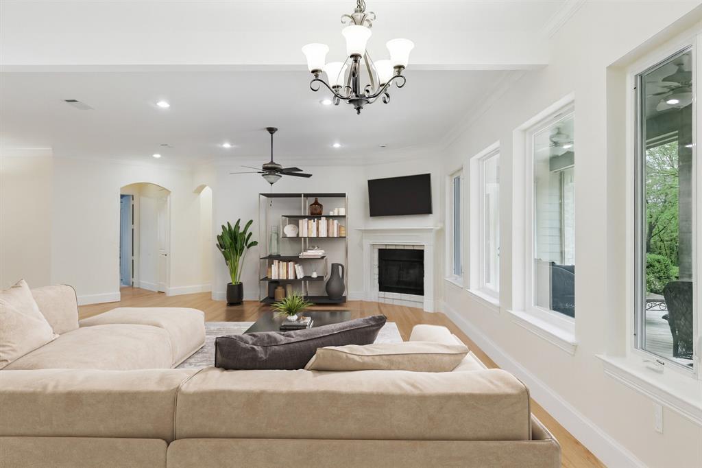 8517 Stallion Street Denton, TX 76208 - Photo 29 of 36 a living room with furniture a chandelier and a fireplace