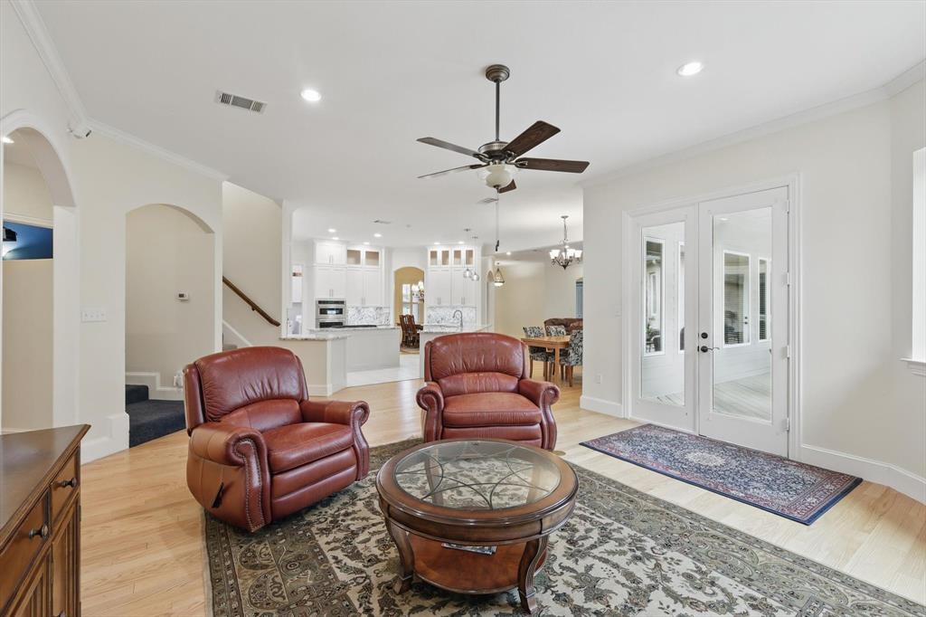 8517 Stallion Street Denton, TX 76208 - Photo 7 of 36 a living room with furniture a rug and a chandelier