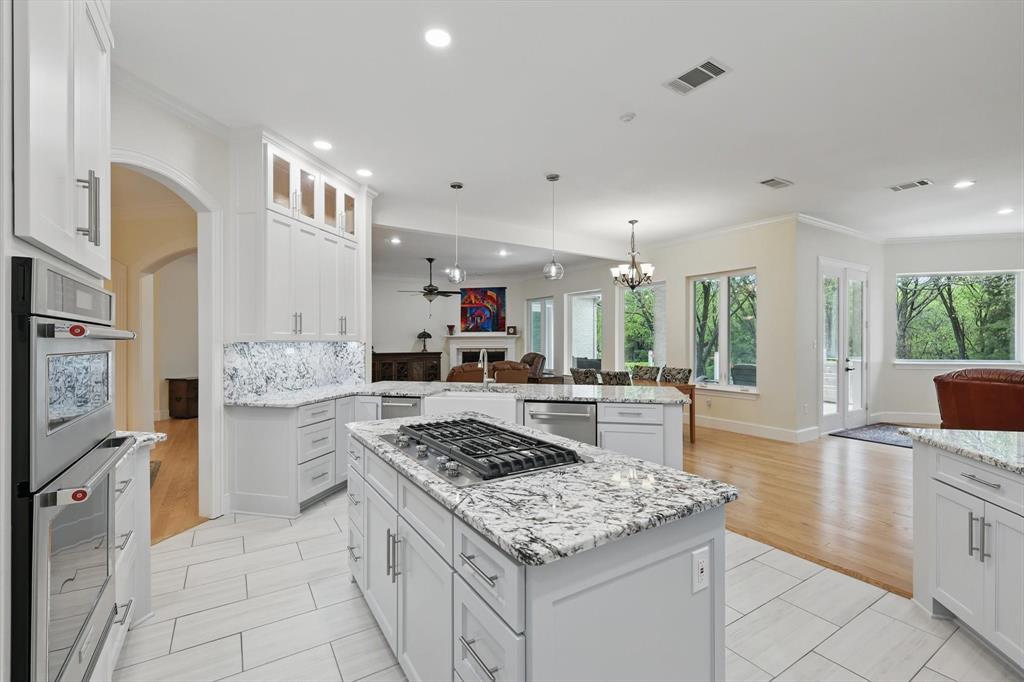 8517 Stallion Street Denton, TX 76208 - Photo 10 of 36 a kitchen with stainless steel appliances granite countertop a stove oven and white cabinets
