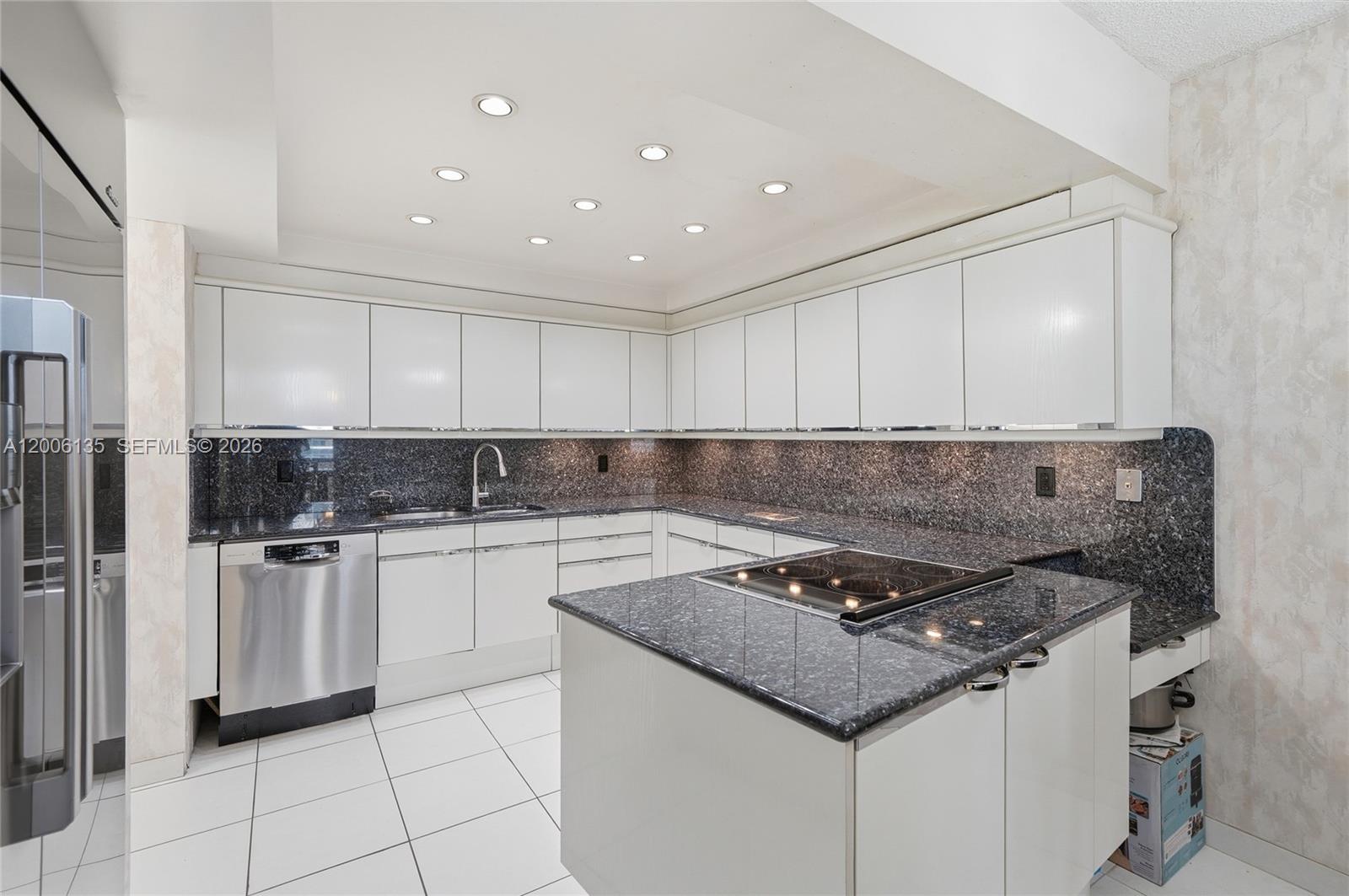 9801 Collins Avenue, Unit 14D Bal Harbour, FL 33154 - Photo 16 of 52 a kitchen with granite countertop a sink stove and refrigerator