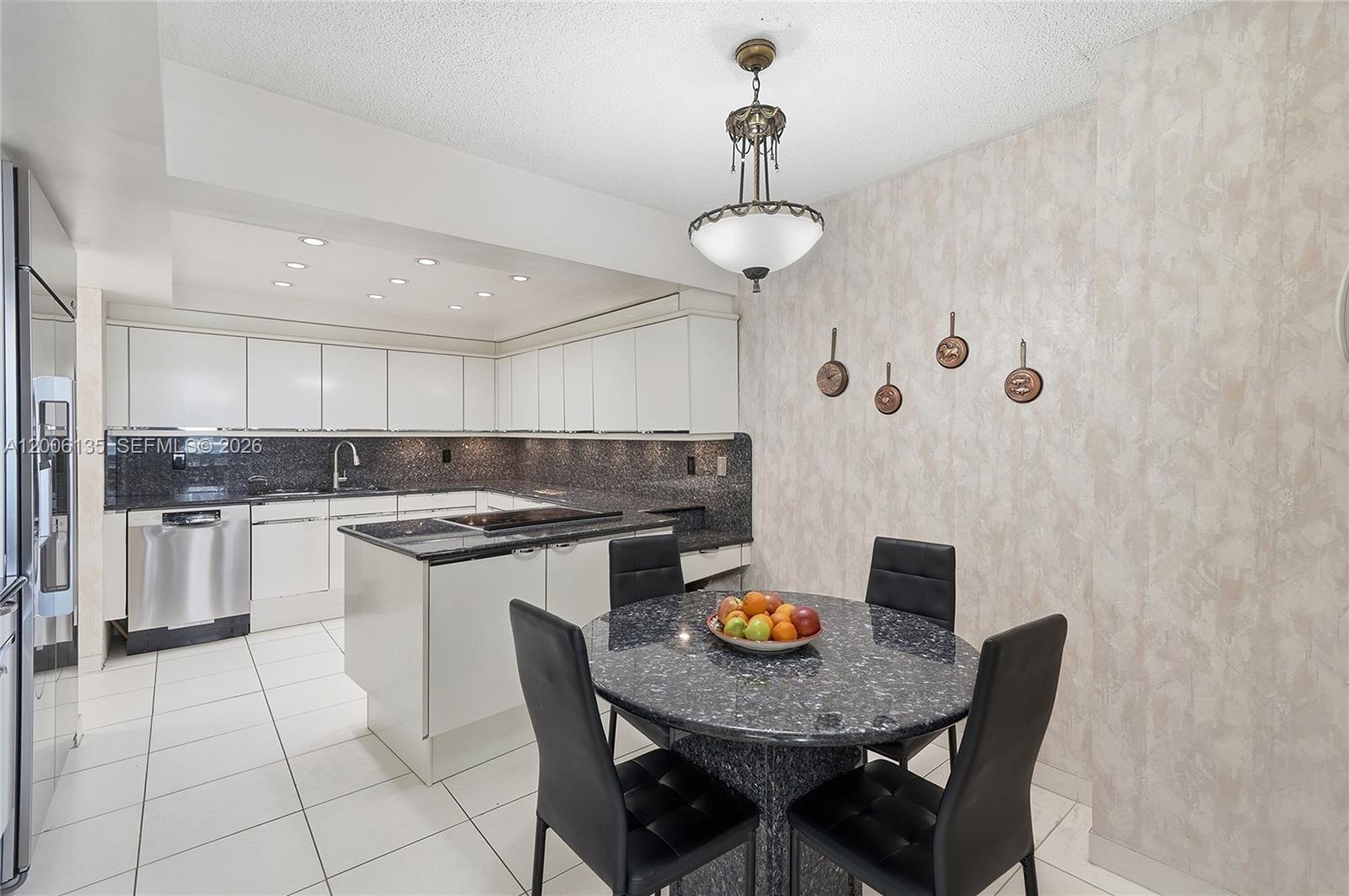 9801 Collins Avenue, Unit 14D Bal Harbour, FL 33154 - Photo 17 of 52 a kitchen with stainless steel appliances granite countertop a sink dishwasher a stove a refrigerator a dining table and chairs with wooden floor