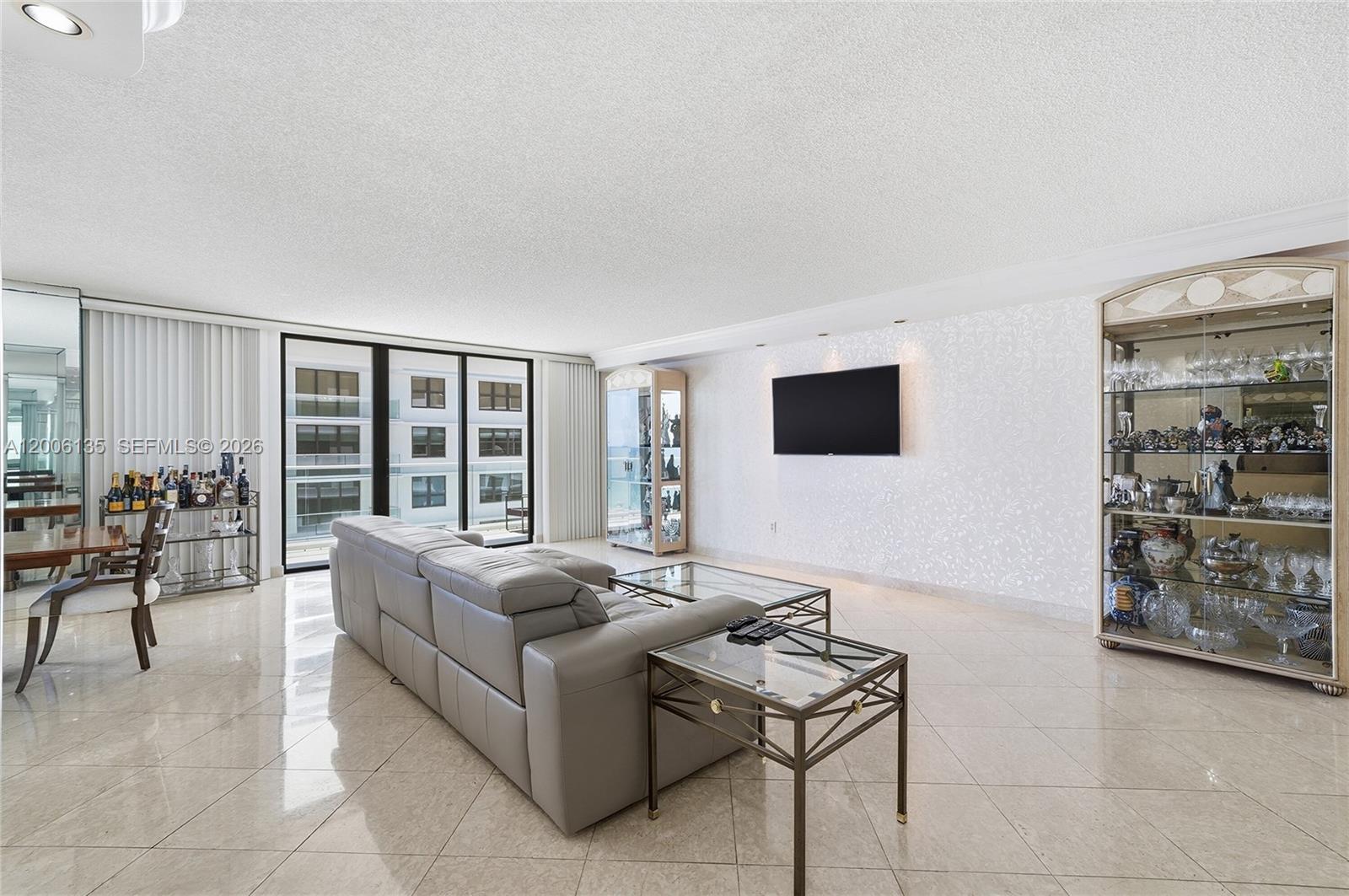 9801 Collins Avenue, Unit 14D Bal Harbour, FL 33154 - Photo 21 of 52 a living room with furniture and a flat screen tv