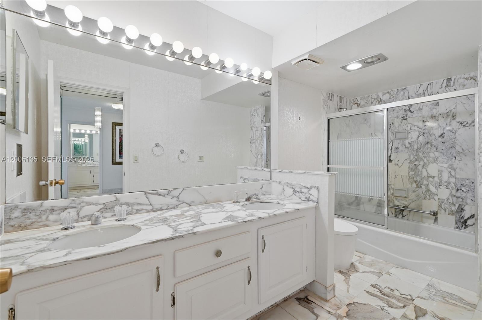 9801 Collins Avenue, Unit 14D Bal Harbour, FL 33154 - Photo 41 of 52 a bathroom with a granite countertop double vanity sink mirror and shower