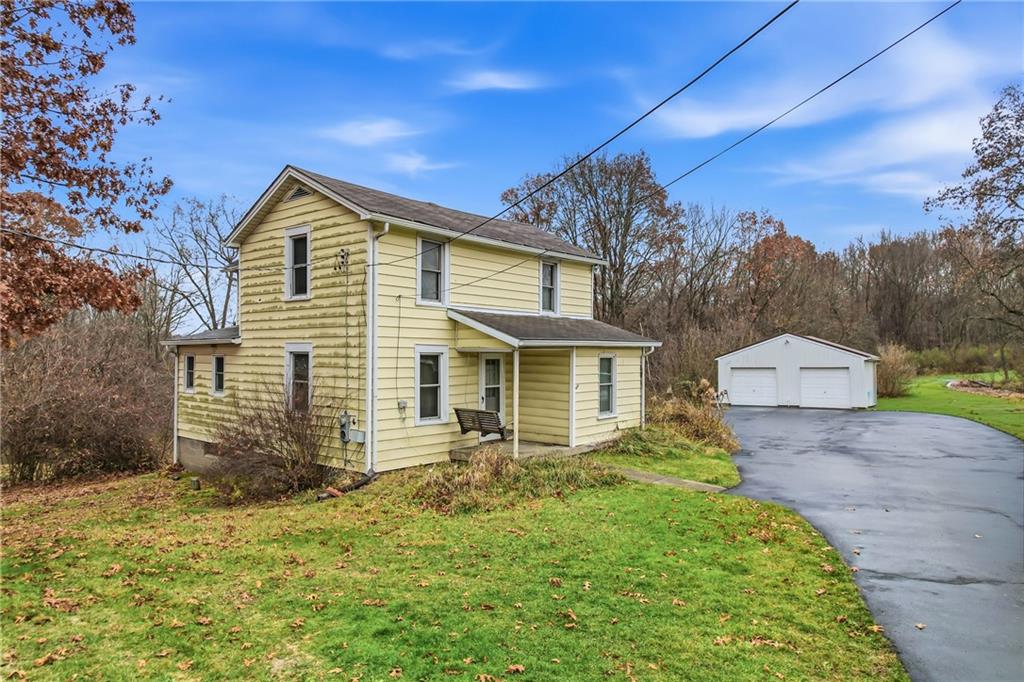 a front view of house with yard and trees in the background