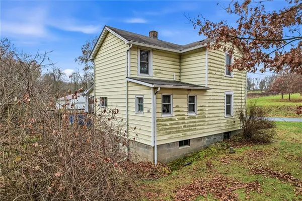 a view of a house with backyard and trees