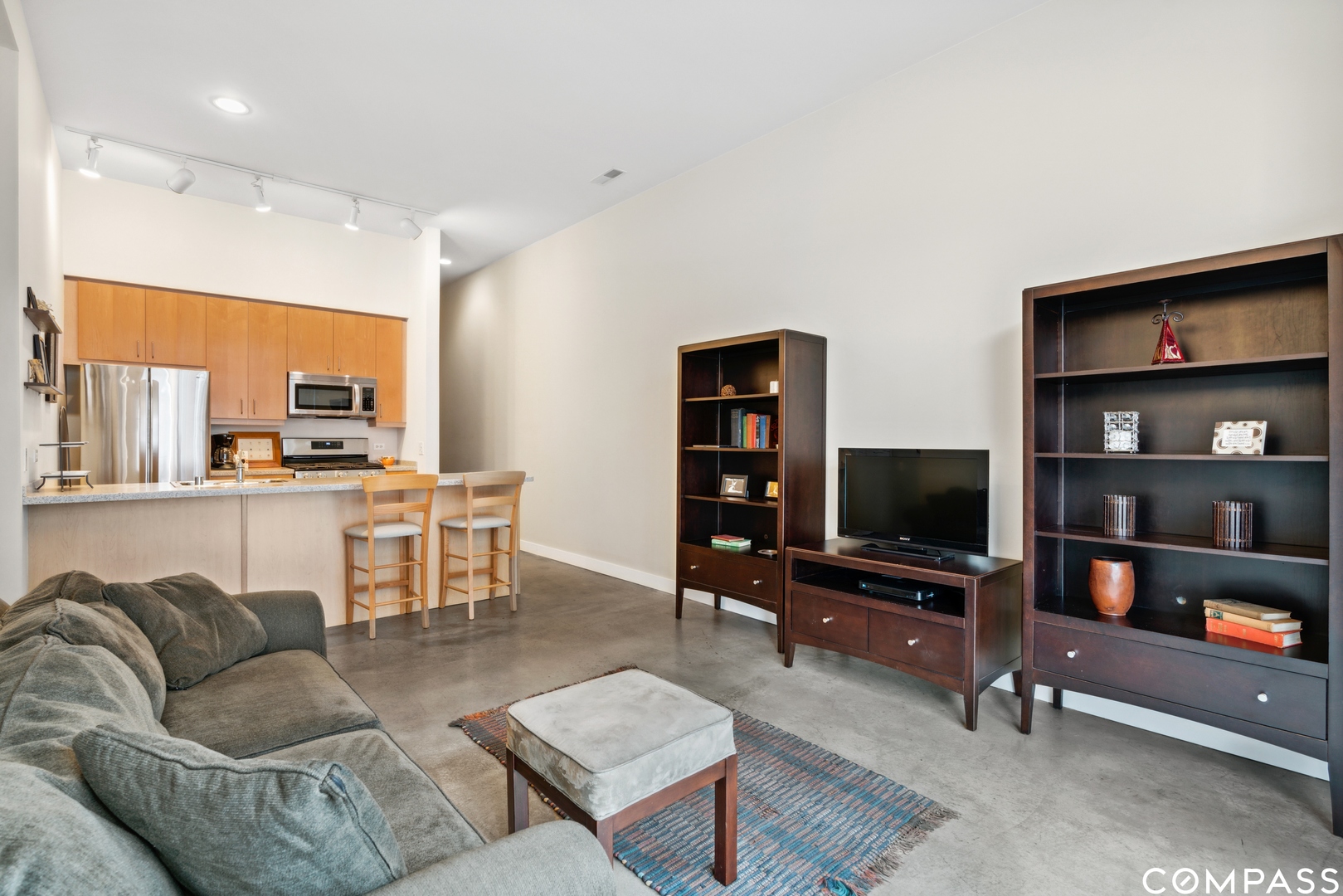 939 West Madison Street, Unit 306 Chicago, IL 60607 - Photo 6 of 15 a living room with furniture a flat screen tv and kitchen view