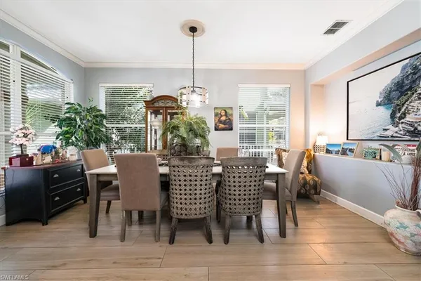 a dining room with furniture a chandelier and wooden floor