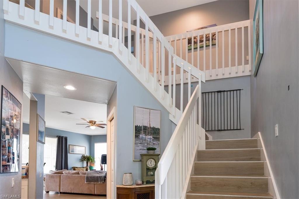 22855 Forest Ridge Drive Estero, FL 33928 - Photo 14 of 49 a view of staircase with lots of frames and a wooden floor
