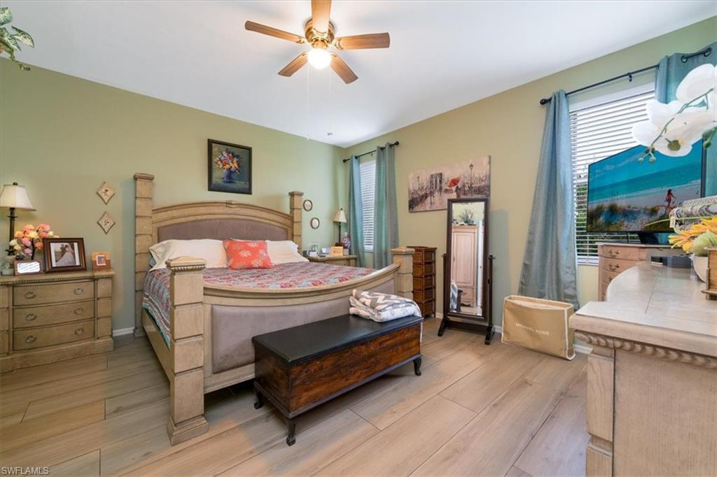 22855 Forest Ridge Drive Estero, FL 33928 - Photo 15 of 49 a bedroom with a bed and a chandelier