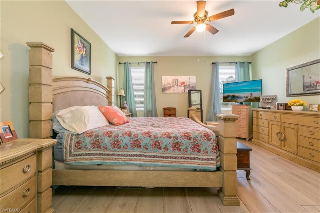 22855 Forest Ridge Drive Estero, FL 33928 - Photo 16 of 49 a bedroom with a bed a dresser and potted plant