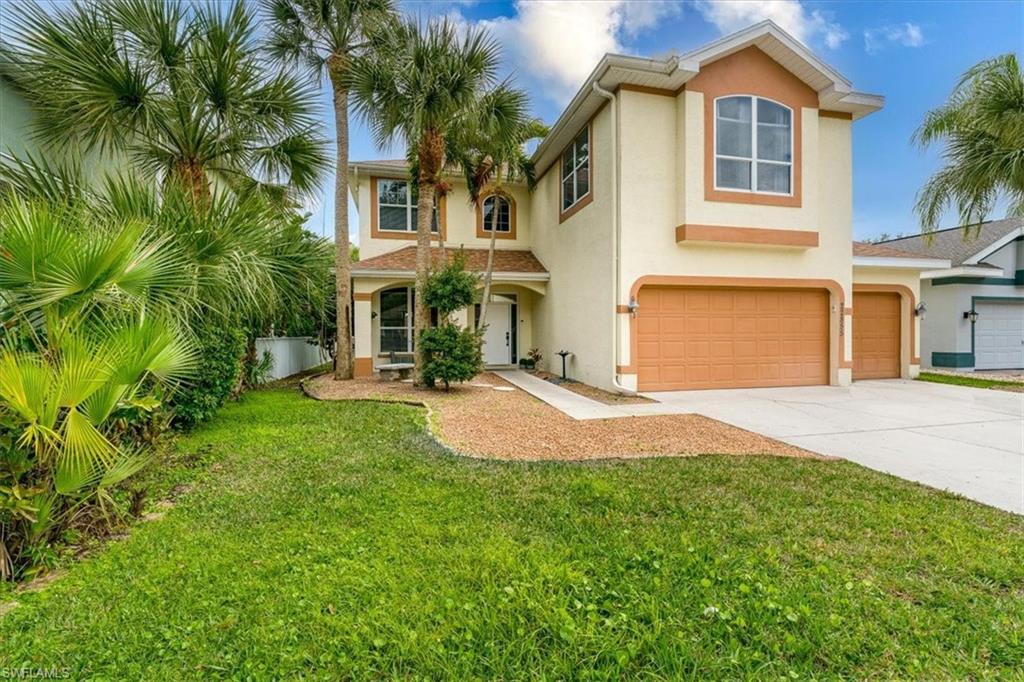 22855 Forest Ridge Drive Estero, FL 33928 - Photo 2 of 49 a front view of a house with a yard and garage