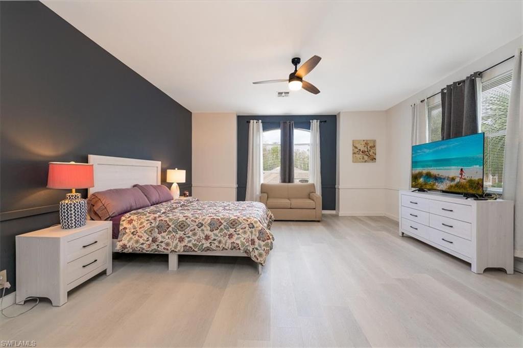 22855 Forest Ridge Drive Estero, FL 33928 - Photo 21 of 49 a bedroom with a bed and a flat screen tv