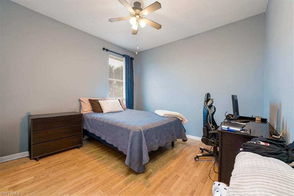 22855 Forest Ridge Drive Estero, FL 33928 - Photo 25 of 49 a bedroom with a bed and a chandelier