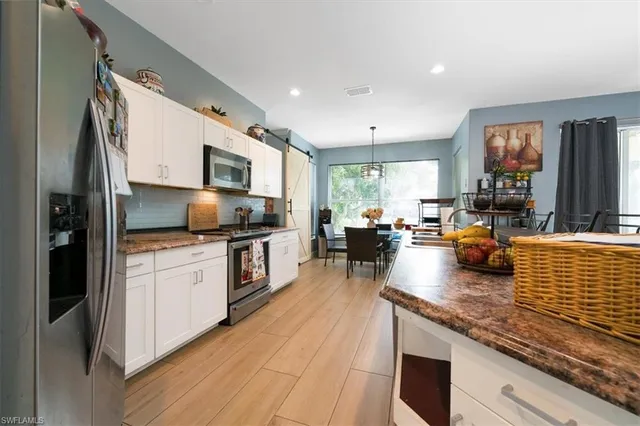 a kitchen with stainless steel appliances granite countertop a refrigerator stove microwave and sink