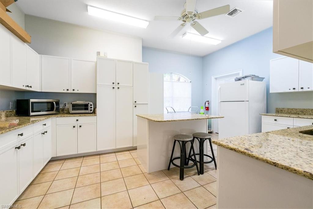 22855 Forest Ridge Drive Estero, FL 33928 - Photo 45 of 49 a kitchen with white cabinets and white appliances