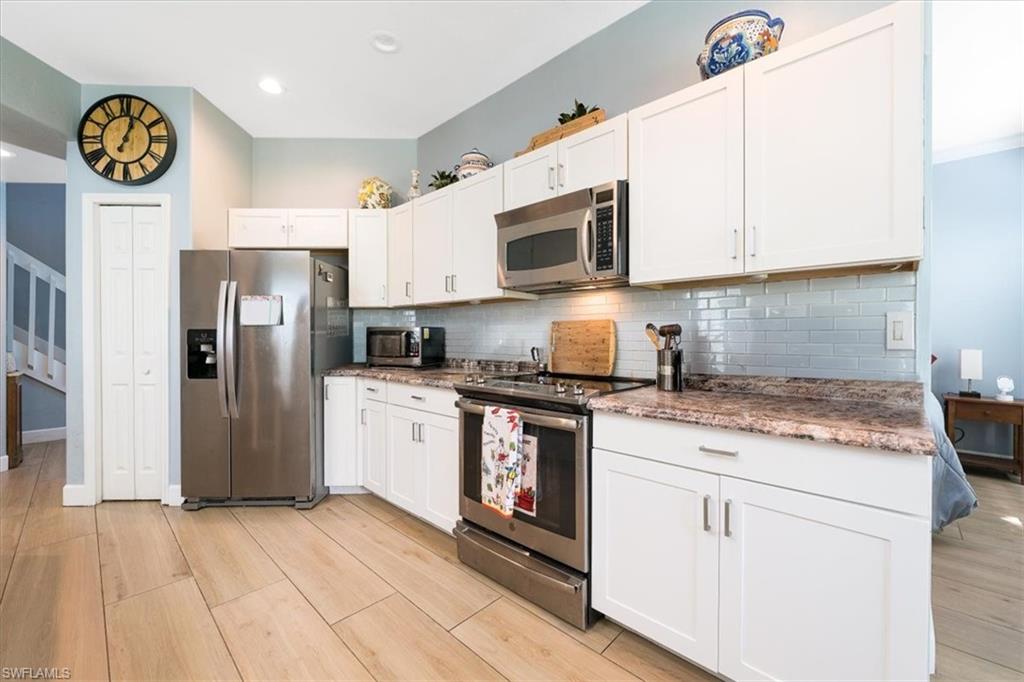22855 Forest Ridge Drive Estero, FL 33928 - Photo 7 of 49 a kitchen with stainless steel appliances granite countertop a refrigerator a stove a sink and a microwave