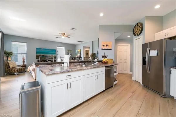 a kitchen with stainless steel appliances granite countertop a refrigerator a stove a sink and a microwave