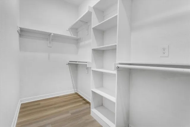 a view of walk in closet with empty racks