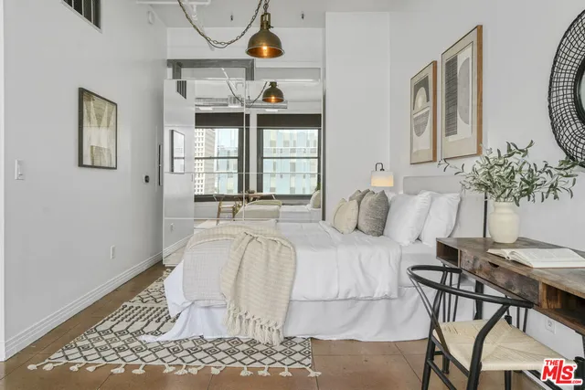 a bedroom with a bed and dresser with mirror