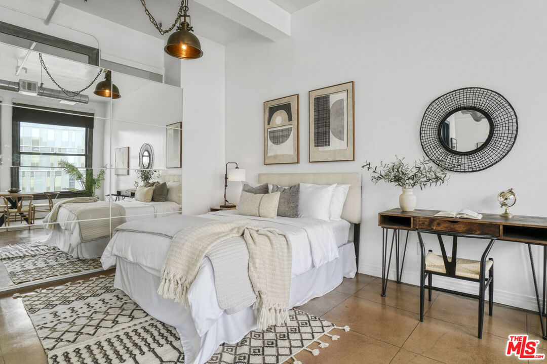 108 West 2nd Street, Unit 915 Los Angeles, CA 90012 - Photo 16 of 27 a living room with a bed furniture and a window