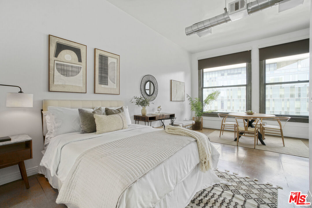 108 West 2nd Street, Unit 915 Los Angeles, CA 90012 - Photo 17 of 27 a bedroom with bed and a large window
