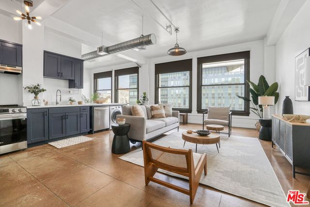 a living room with furniture a large window and a dining table