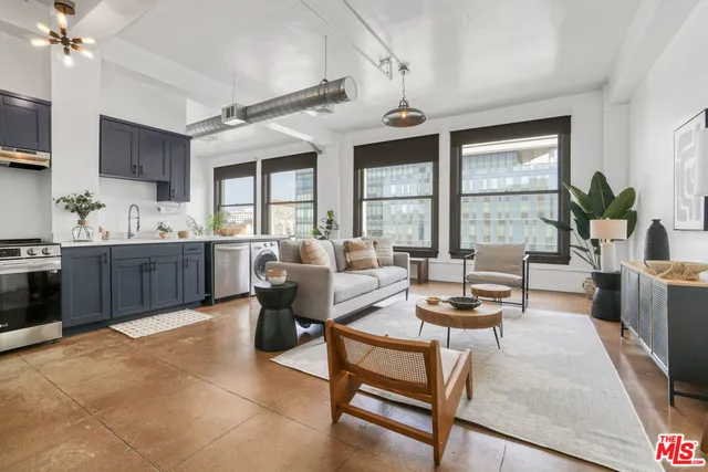 a living room with furniture a large window and a dining table