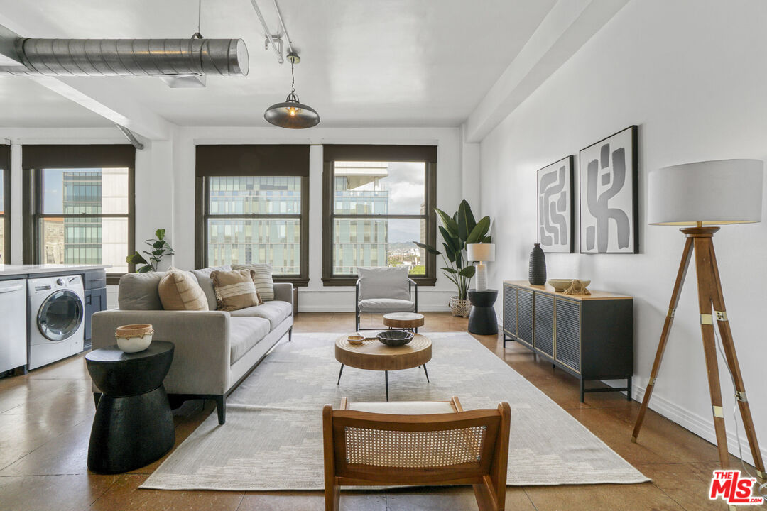108 West 2nd Street, Unit 915 Los Angeles, CA 90012 - Photo 3 of 27 a living room with furniture potted plant and a large window