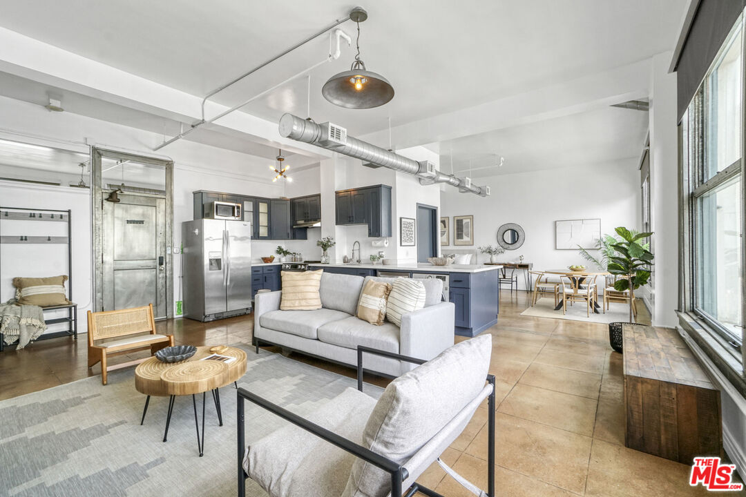 108 West 2nd Street, Unit 915 Los Angeles, CA 90012 - Photo 7 of 27 a living room with furniture and a chandelier