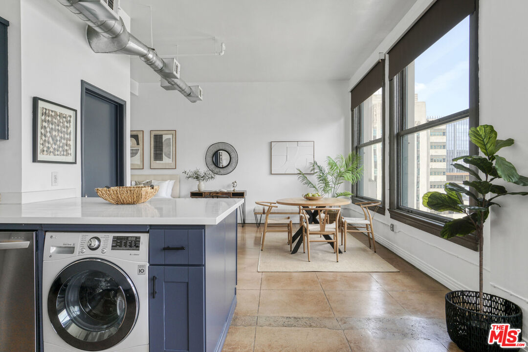 108 West 2nd Street, Unit 915 Los Angeles, CA 90012 - Photo 8 of 27 a living room with furniture a chandelier and a window