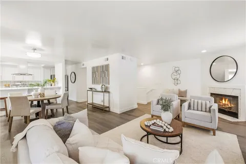 a living room with furniture kitchen view and a fireplace