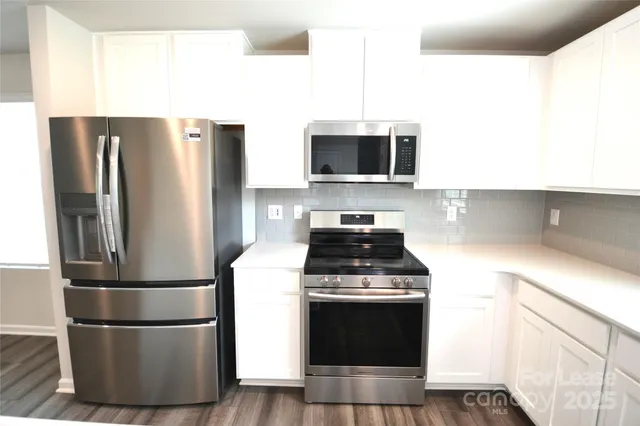 a kitchen with a refrigerator stove and microwave