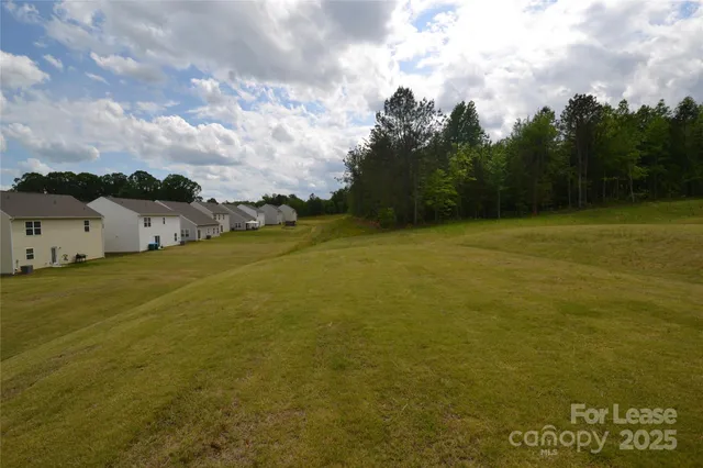 a front view of house with yard and trees in the background