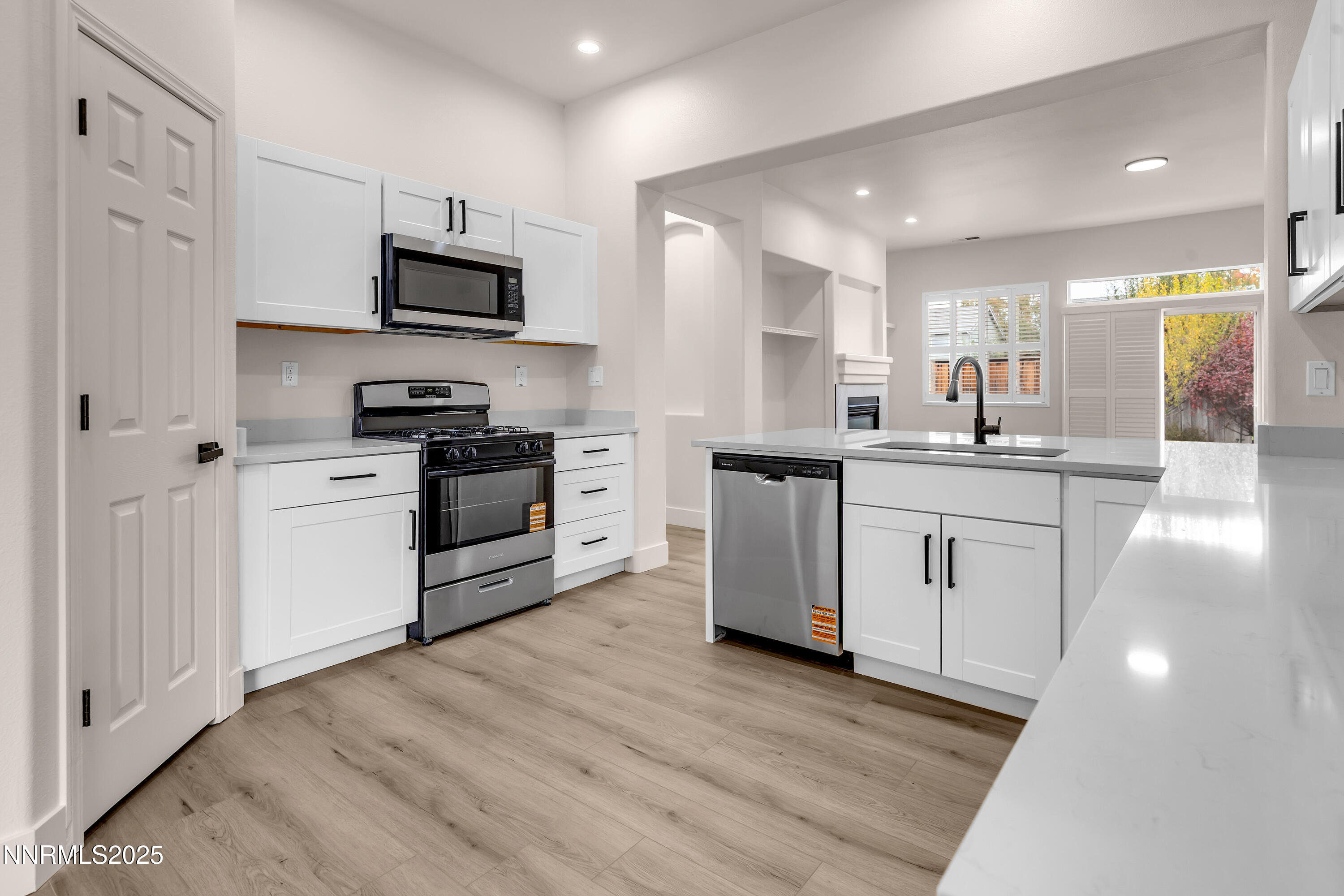 1651 Emerald Bay Drive Reno, NV 89521 - Photo 17 of 50 a kitchen with stainless steel appliances a sink a stove a microwave a center island and cabinets