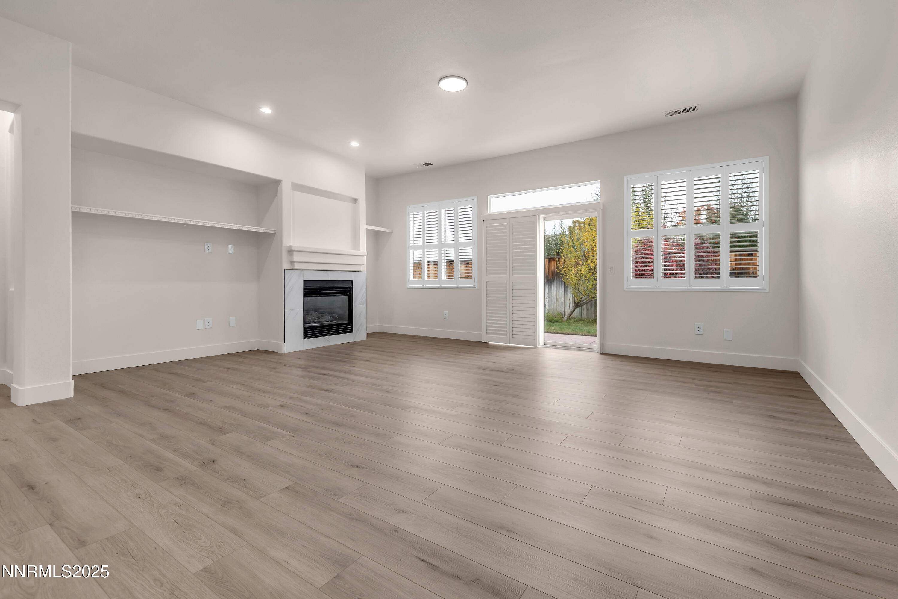 1651 Emerald Bay Drive Reno, NV 89521 - Photo 4 of 50 an empty room with wooden floor and fireplace