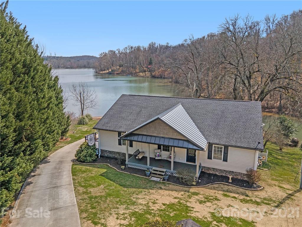 an aerial view of a house with swimming pool next to a big yard