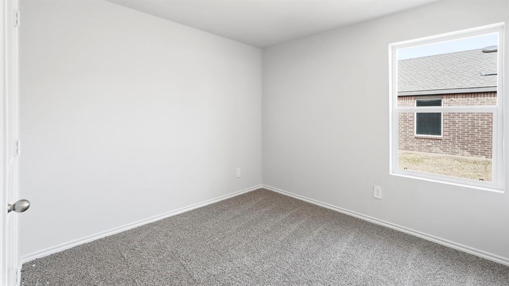 3319 Twilight Trail Forney, TX 75126 - Photo 26 of 33 Spacious room featuring neutral paint, gray carpet, a single window, white trim, and a white door with a brushed nickel knob