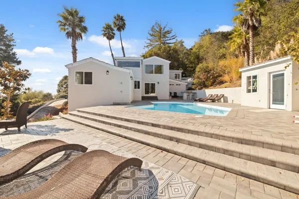 a view of a back yard of the house along with trees
