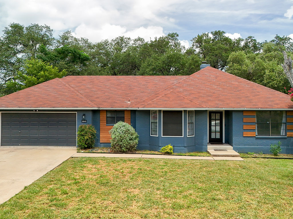 5842 Secrest Drive Austin, TX 78759 - Photo 1 of 40 A well-maintained facade features a prominent driveway leading to an attached garage.