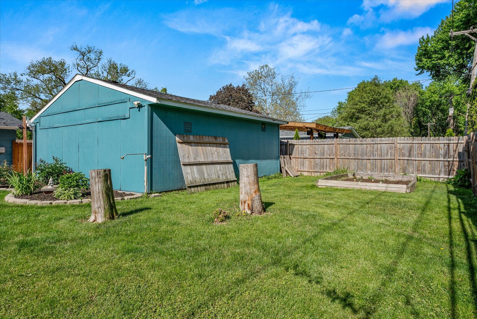 14 Hampton Road Montgomery, IL 60538 - Photo 21 of 27 a backyard of a house with plants and wooden fence