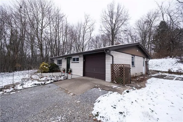 a front view of a house with a yard covered in snow